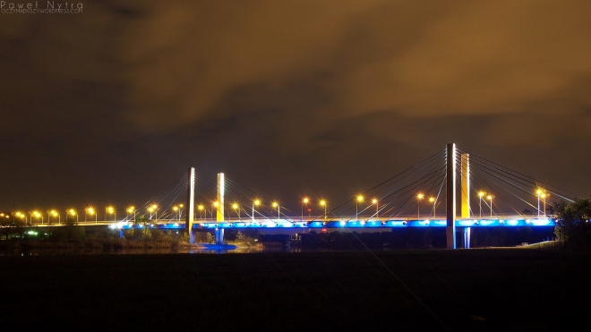 Most Milenijny nocą, widziany z brzegu Odry